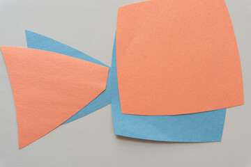 pale orange and blue construction paper shapes on a blank paper background