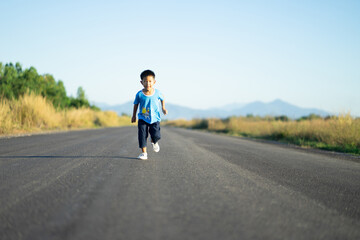 a boy running on the street in the morning