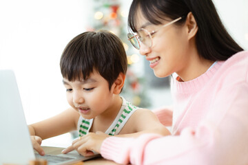 Asian little lovely boy learning or studying at home with his mother.