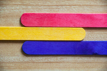 Top view of colored wooden sticks with customizable space for text. Copy space and color background concept.