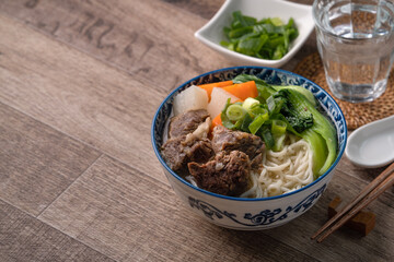 Beef noodle soup. Close up of Taiwanese famous food in a bowl on wooden table.