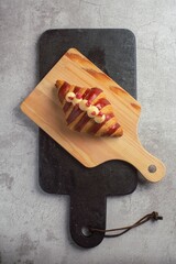 French Croissant on slate and wooden chopping board with concrete background