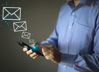 Businessman hands using Smart Phone and surfing the internet on office table with email icon, email marketing concept, send e-mail or news letter, online working internet network.