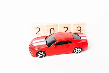 2023 Wooden numbers are isolated on white background. Festive red car copy space