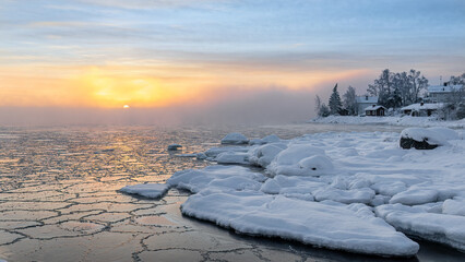 Frosty morning and freezing sea at sunrise