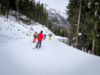 several skiers skiing down a mountain