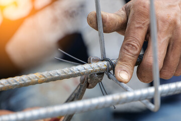 Fototapeta na wymiar Workers are using steel wire to bind steel bars for foundation structures in the chemical plant construction site