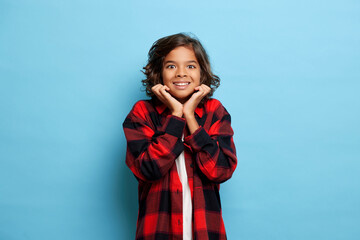 young handsome guy in a plaid shirt smiling broadly and beautifully with white teeth, holds his...