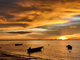 View of fishing boats with the sunset in the background