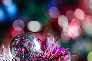 Close-up of Christmas decorations on a tree through lensball sphere