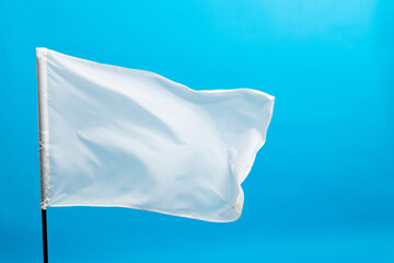 White flag waving on blue background - obrazy, fototapety, plakaty