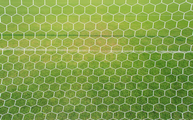 football net with green grass background. View from the back of the football field.