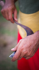 a man holding sickle for cutting weeds
