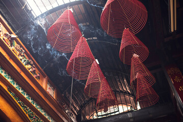 Large red incense coils hanging from ceiling of Taoist Temple in Saigon,...