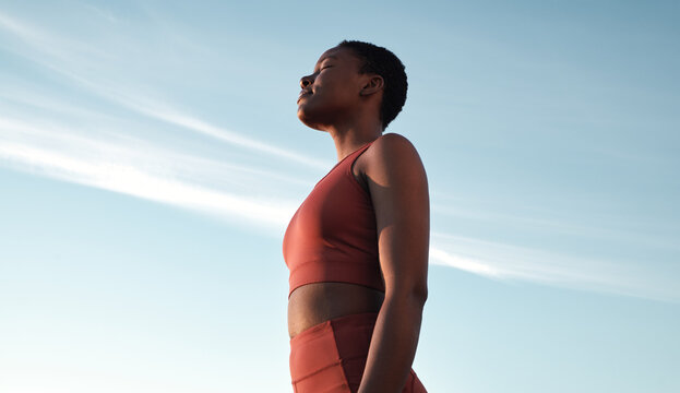Fitness, meditation and woman on blue sky to breathe fresh air, freedom and energy to exercise, workout and do yoga or cardio training outdoor in nature. Black female take breath for mental health - Powered by Adobe