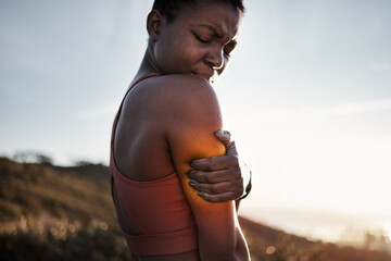 Black woman, sports fitness and arm pain after exercise accident outdoors. Sunset, health and young...