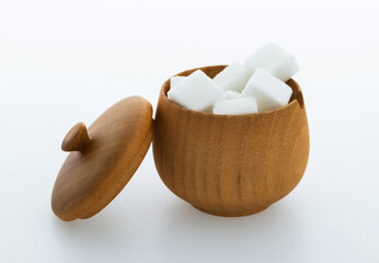 Sugar cubes in a bowl on white background