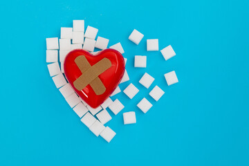 Red heart with bandage on sugar cubes