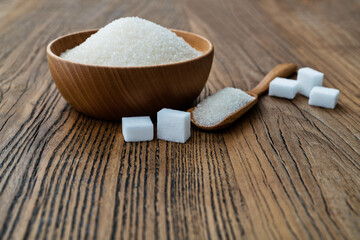 A bowl granulated sugar and sugar cubes on the table