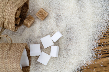 Fototapeta na wymiar Sugar cubes on top of granulated sugar