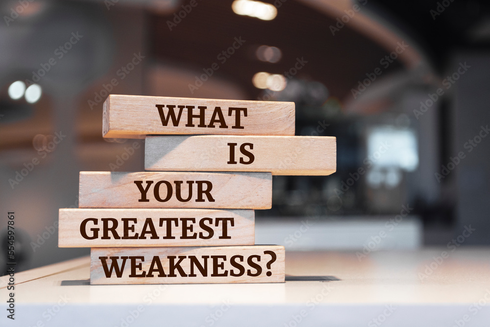 Wall mural wooden blocks with words 'what is your greatest weakness?'.