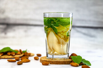 Tea with almonds, pear and mint in a glass