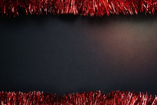 Red Tinsel Frame On Black Paper Background