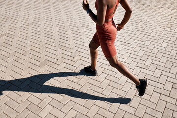 Running, runner and woman with fitness in city, training for marathon and exercise with cardio workout in Seattle. Urban, run outdoor with health and wellness, active life and athlete shadow in sport
