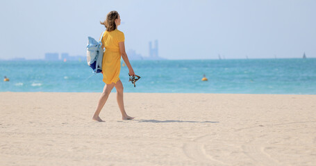 Fototapeta premium Woman goes to the sea with a backpack on her back