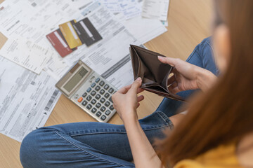 Stressed, problem people asian woman, girl sitting on floor at home, hand holding wallet open empty purse no money to pay bill, loan or expense in payment. Bankruptcy, bankrupt and debt financial. - obrazy, fototapety, plakaty