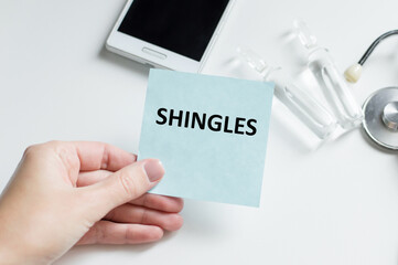 Doctor holding a card with text Shingles,medical concept