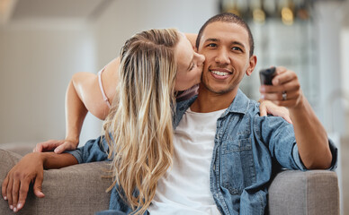 Couple, sofa and woman with cheek kiss for man, partner or husband with love, romance and care in home. Girl, surprise and kissing face of black man for bonding, happiness and relationship on couch - obrazy, fototapety, plakaty
