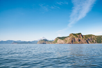 Summer landscape of the coastline with snow covered volcano. Kamchatka