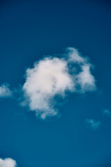 Single white cloud in the blue sky. Background texture of a summer sky.