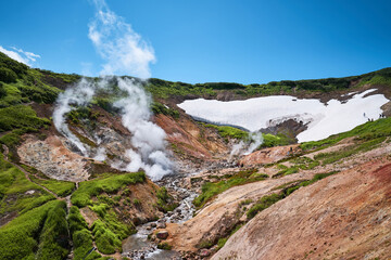 Fototapeta na wymiar Steaming mud holes and solfataras in the geothermal area of Kamchatka peninsula. Summer landscape