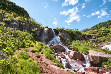 Summer landscape with a small waterfall. Kamchatka