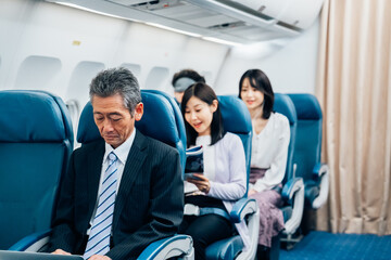 飛行機で出張に出かけるミドルのビジネスマン