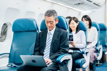 飛行機で出張に出かけるミドルのビジネスマン