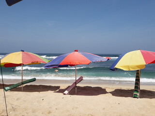Colorful beach umbrella on the white sand beach.