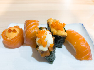 Salmon sushi rolls variety on white plate. Traditional Japanese raw food concept