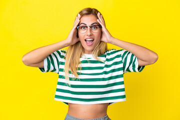 Blonde Uruguayan girl isolated on yellow background with surprise expression