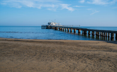 Sandy beach and restaurant on stilts at sea