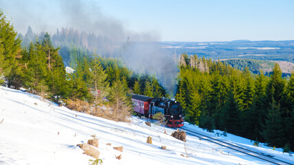 Steam train during winter in the snow in the Harz national park Germany