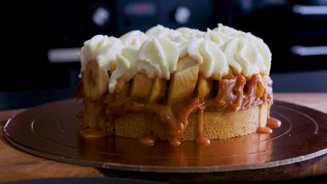 Banoffi cake made of shortbread, bananas and homemade caramel, cake with bananas, caramel and cream , cut a piece