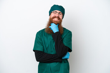 Surgeon redhead man in green uniform isolated on white background with glasses and smiling