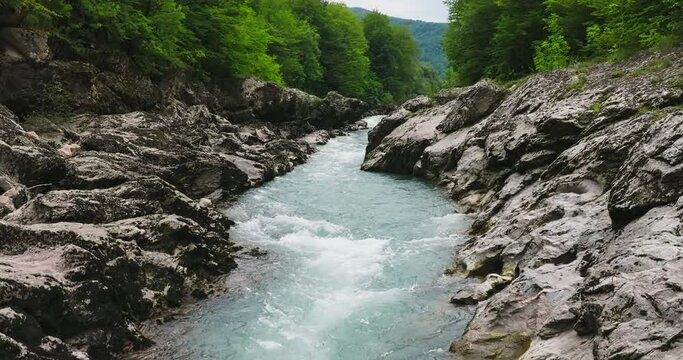 Aerial view of Mountain river and road. Flying over a mountain gorge. Slow motion 120 fps.