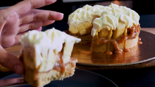 Banoffi cake made of shortbread, bananas and homemade caramel, cake with bananas, caramel and cream , cut a piece
