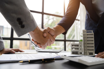 Fototapeta Close up shake hands, Considering buying a home, investing in real estate. Broker signs a sales agreement. agent, lease agreement, successful deal. obraz