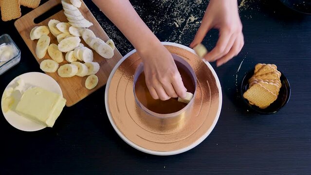 Banoffi cake, the cooking process. Cake without baking on shortbread dough. Banoffi, a cake with bananas, caramel and cream