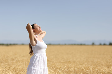 Woman in white dress breathing in a field